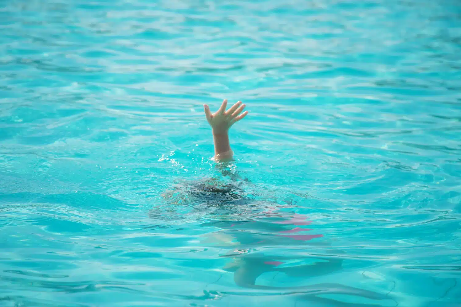 La main d'un enfant dans une piscine