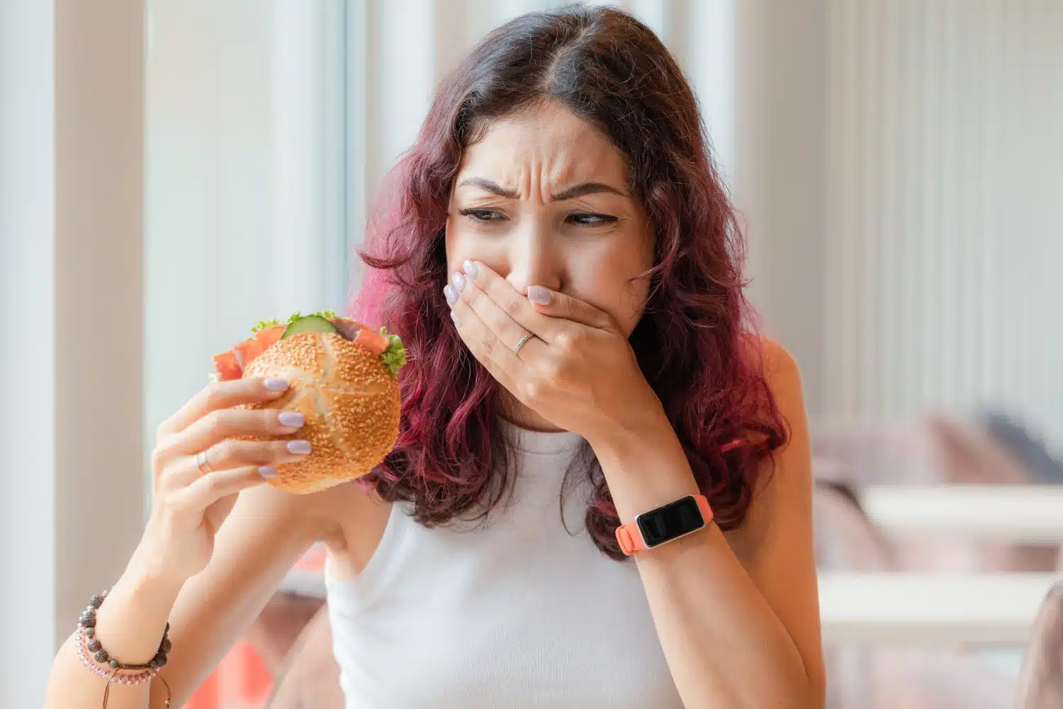 Une jeune femme s'étouffe avec un hamburger