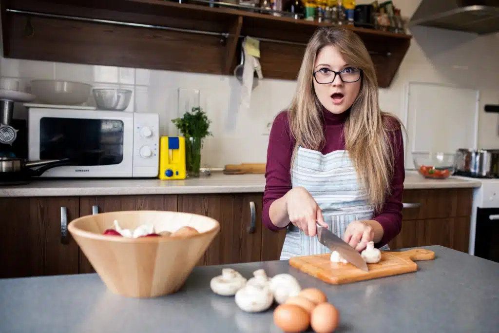 Une femme en train de cuisiner avec un couteau tranchant