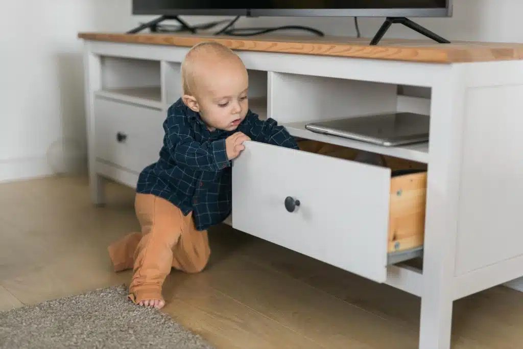 Un jeune enfant s'agrippe à un meuble