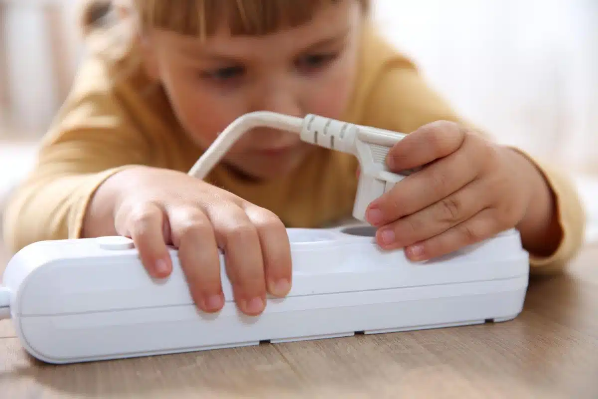 Une petite fille qui joue avec une prise électrique