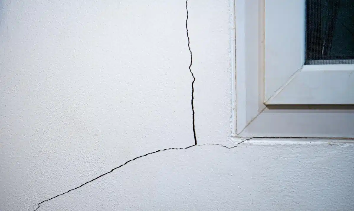 Fissure sur un mur de maison proche d'une fenetre